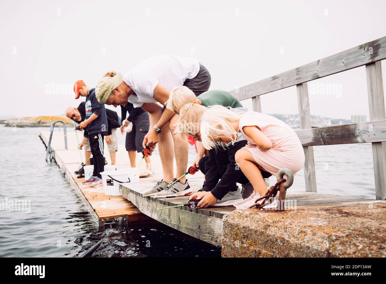 Padre con bambini che pescano Foto Stock