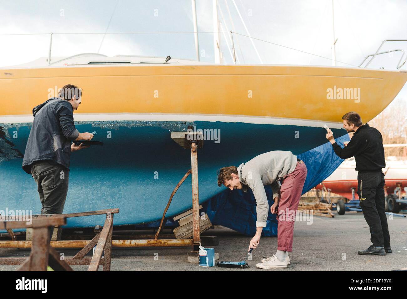 Uomini pittura barca insieme Foto Stock