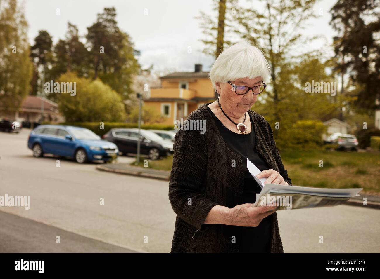 Donna anziana che tiene il giornale Foto Stock