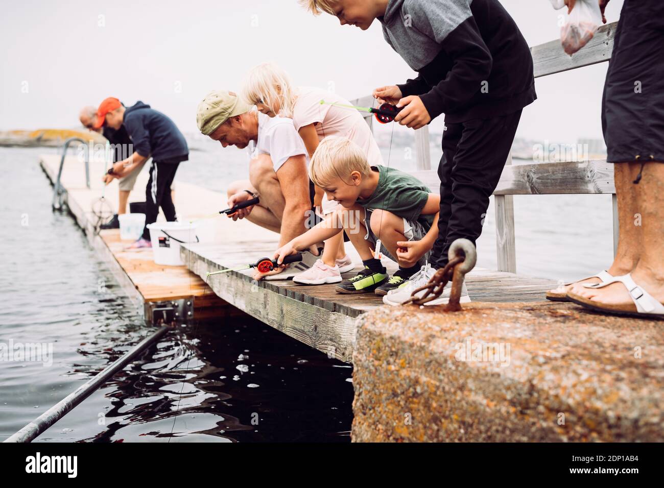Padre con bambini che pescano Foto Stock