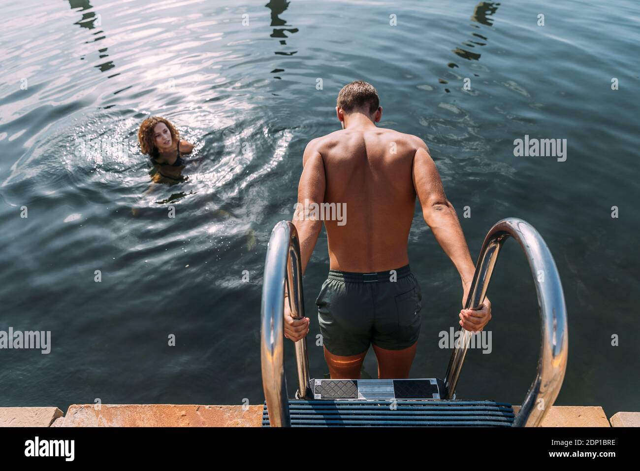 Giovane uomo per arrivare in acqua dal molo Foto Stock