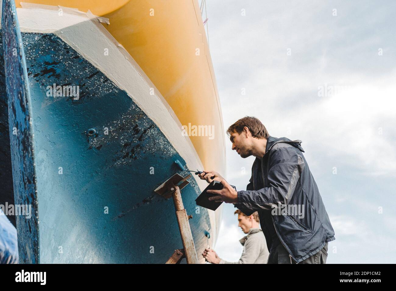 Gli uomini la barca di verniciatura Foto Stock