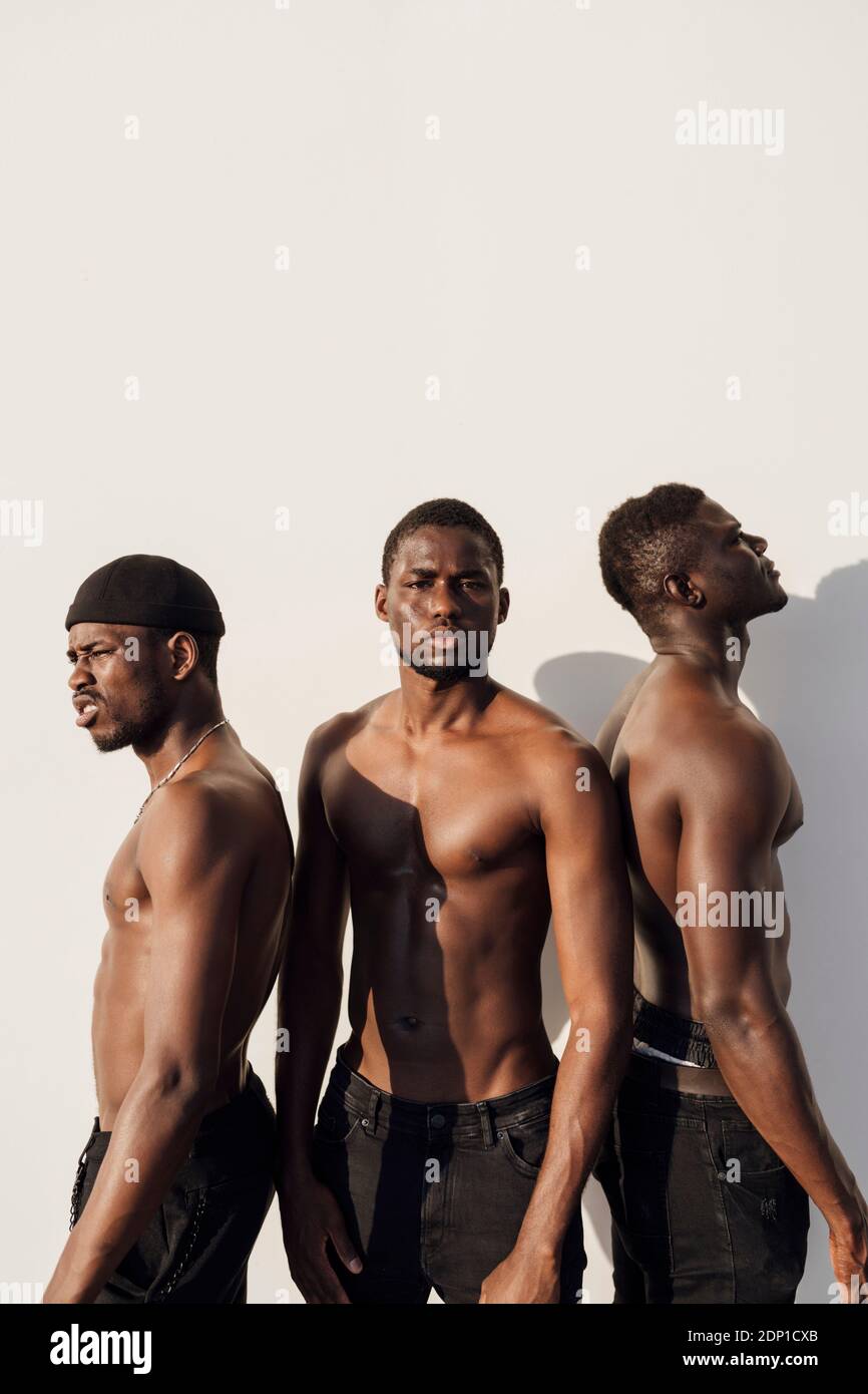 Tre uomini neri con petto nudo in piedi di fronte parete bianca Foto stock  - Alamy