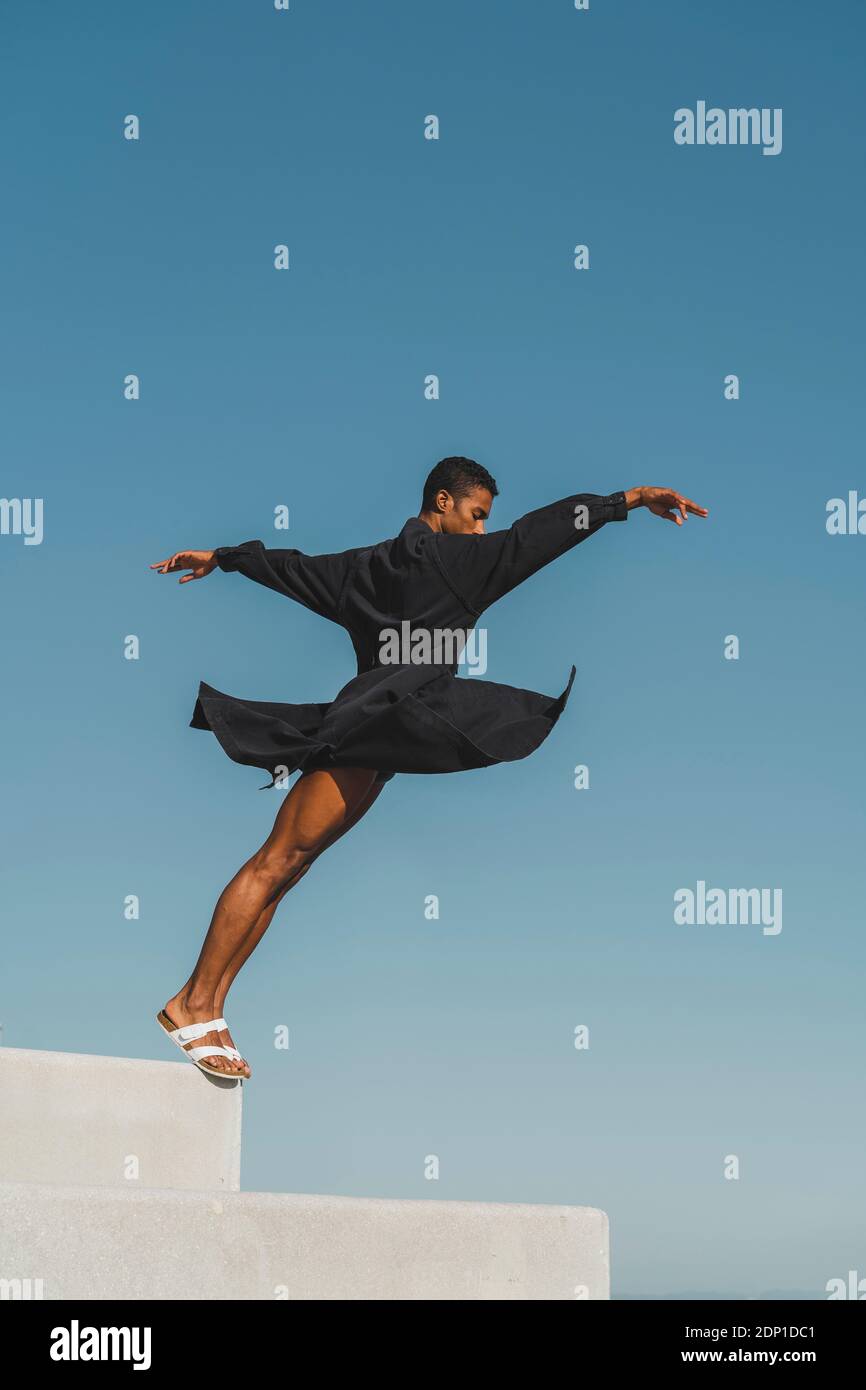 Giovane uomo che indossa kaftan nero che si esibisce all'aperto Foto Stock
