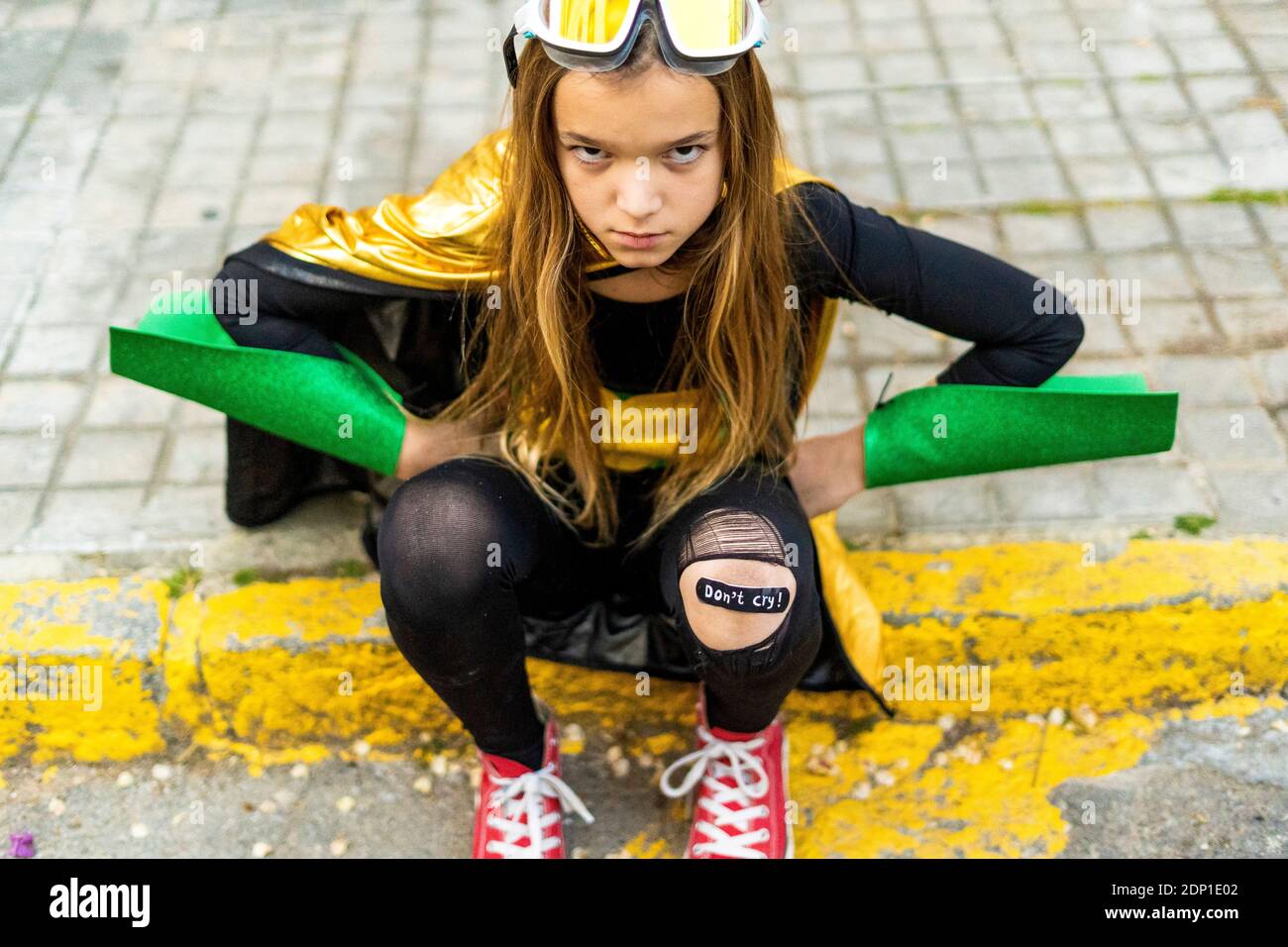 Ragazza in posa di super eroina costume seduta sul marciapiede Foto stock -  Alamy