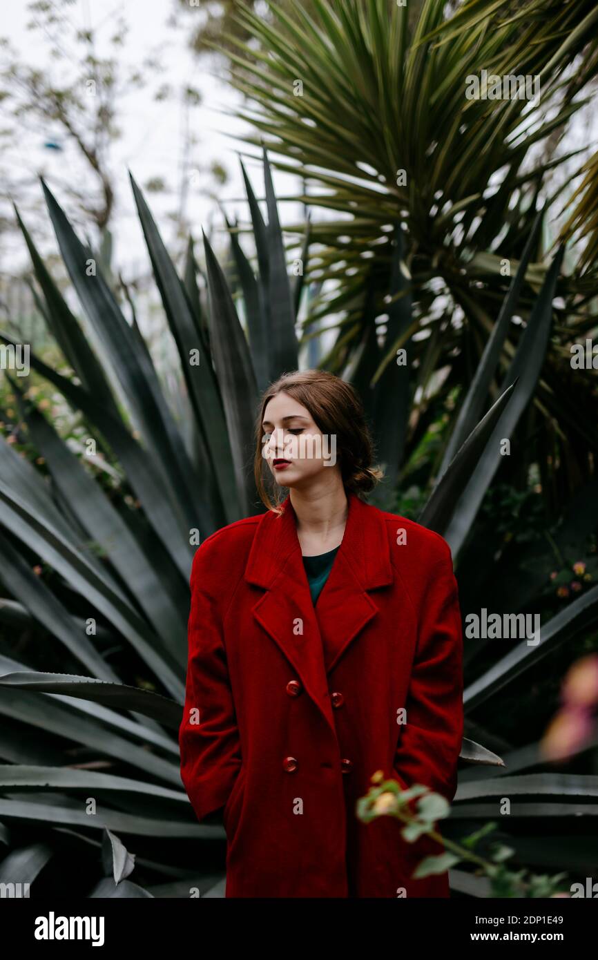 Donna con cappotto rosso in un parco Foto Stock