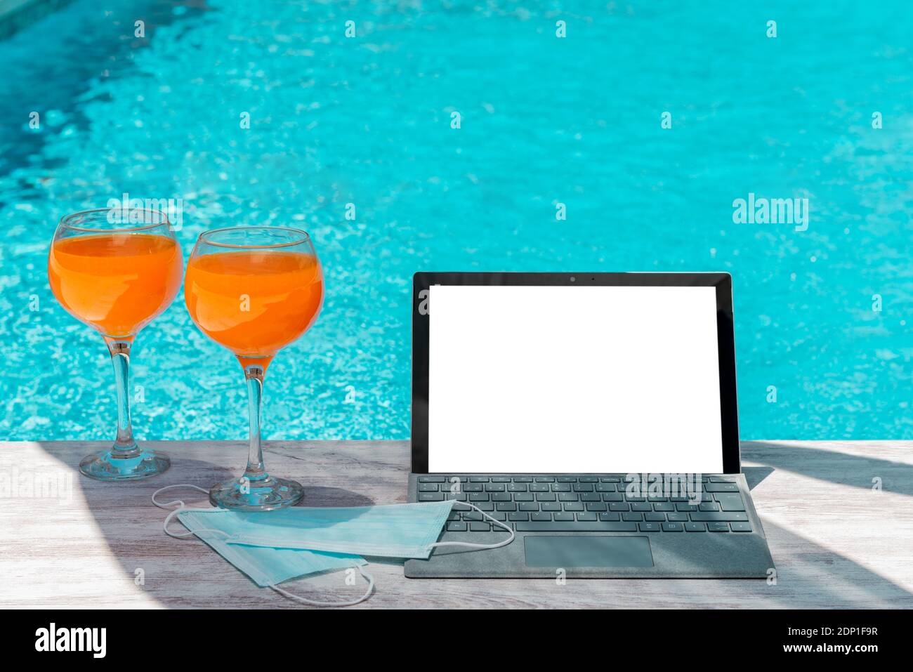 computer per succo d'arancia e maschere di protezione per coronavirus covid-19 in piscina Foto Stock