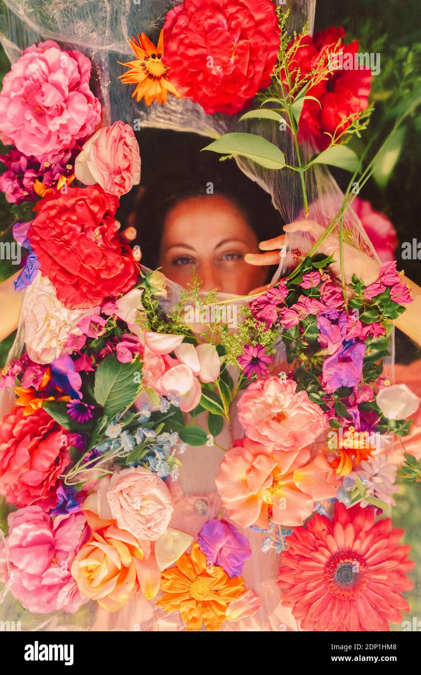Bella donna che guarda attraverso il velo con fiori Foto Stock