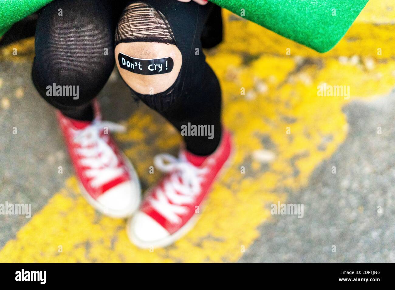 Close-up di band-aiuto sulla ragazza in ginocchio infortunato Foto Stock