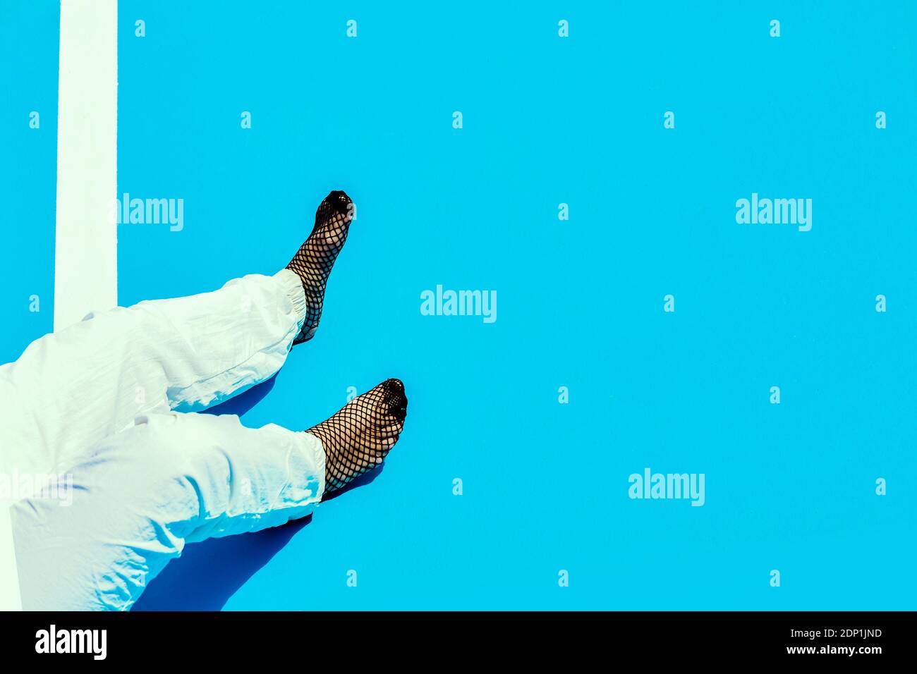 Donna che indossa lo stile swag, in piedi sul pavimento blu Foto Stock