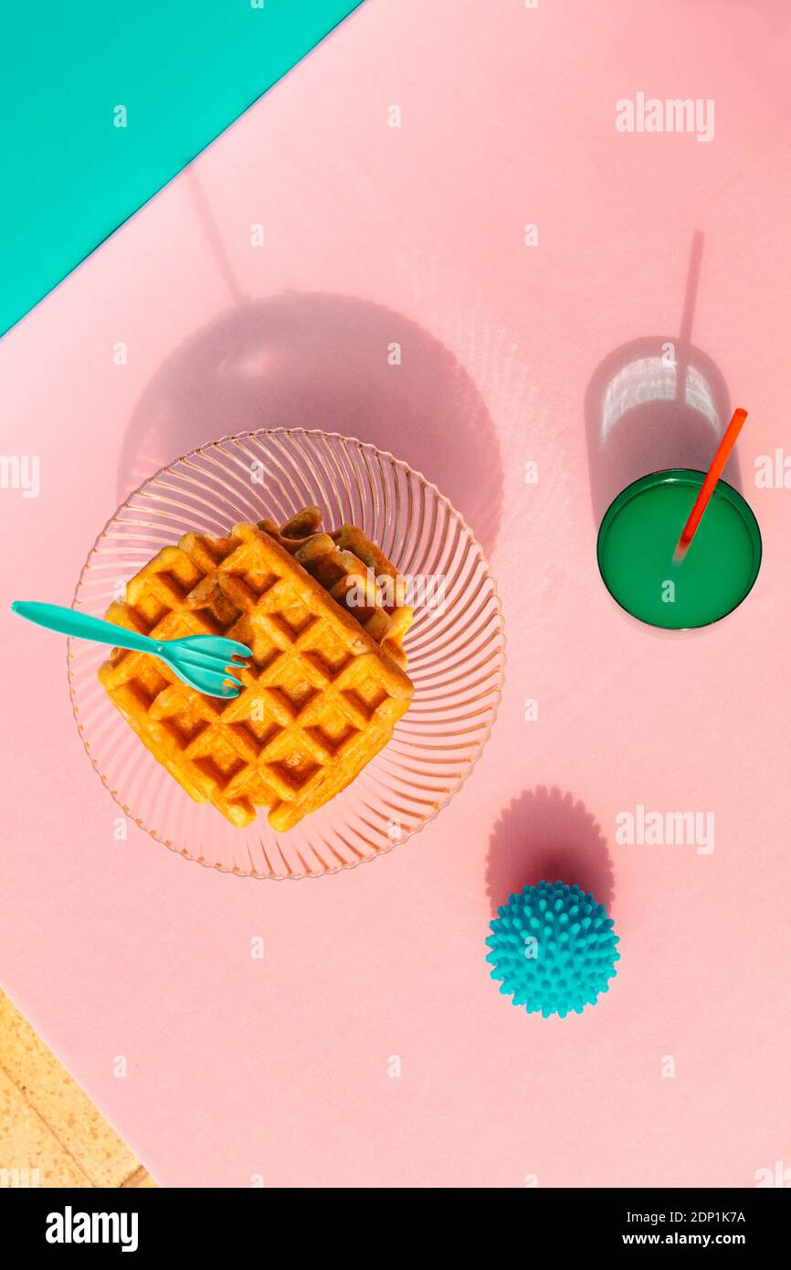 Direttamente sopra la vista di waffle, succo di frutta, palla di gomma tenuta sul tavolo Foto Stock