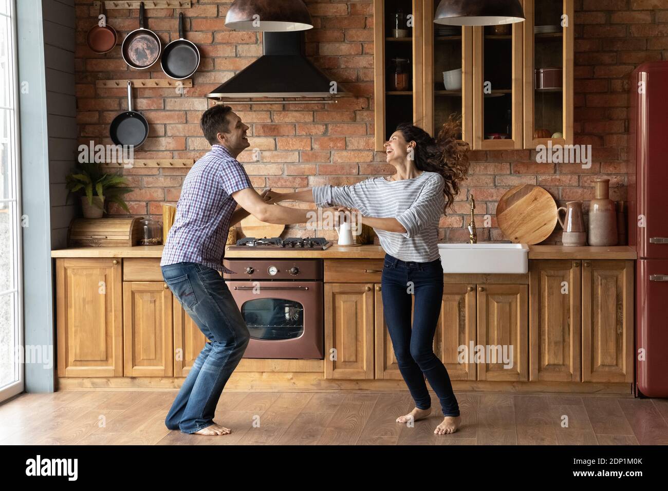 Una coppia millenaria che danzava in cucina eccitata dal rilocamento Foto Stock