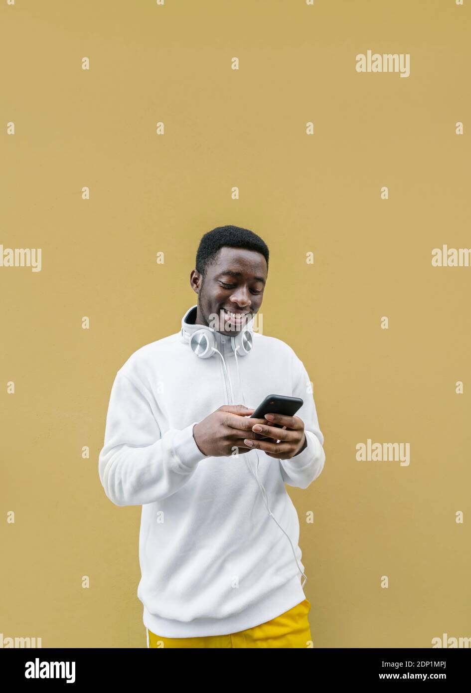 Ritratto di un giovane sorridente che guarda lo smartphone Foto Stock