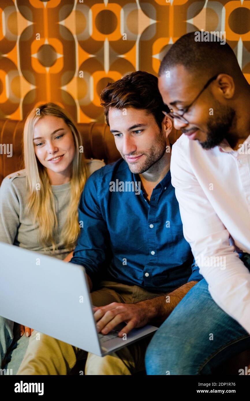 Tre persone sedute sul divano nel soggiorno vintage Camera portatile di condivisione Foto Stock