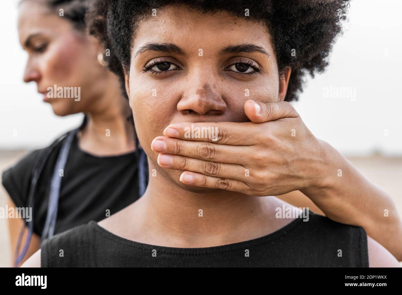 Donna di mano che copre la bocca di un'altra donna, close-up Foto Stock