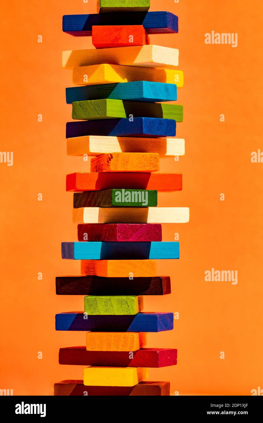 Blocchi giocattolo colorati impilano su sfondo arancione Foto Stock