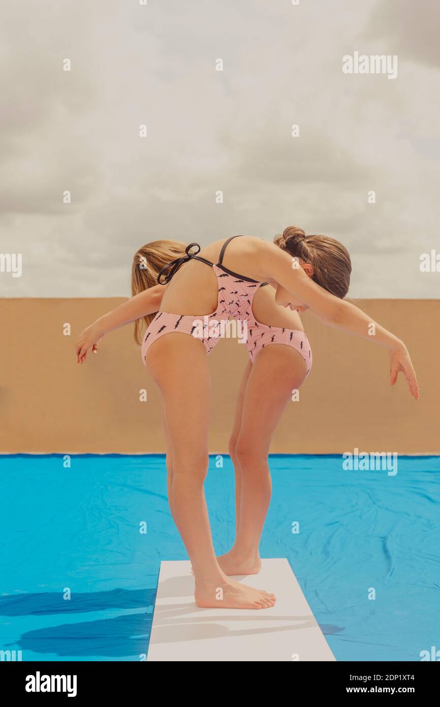 Due ragazze che giocano a swimmingpool sulla terrazza sul tetto Foto Stock