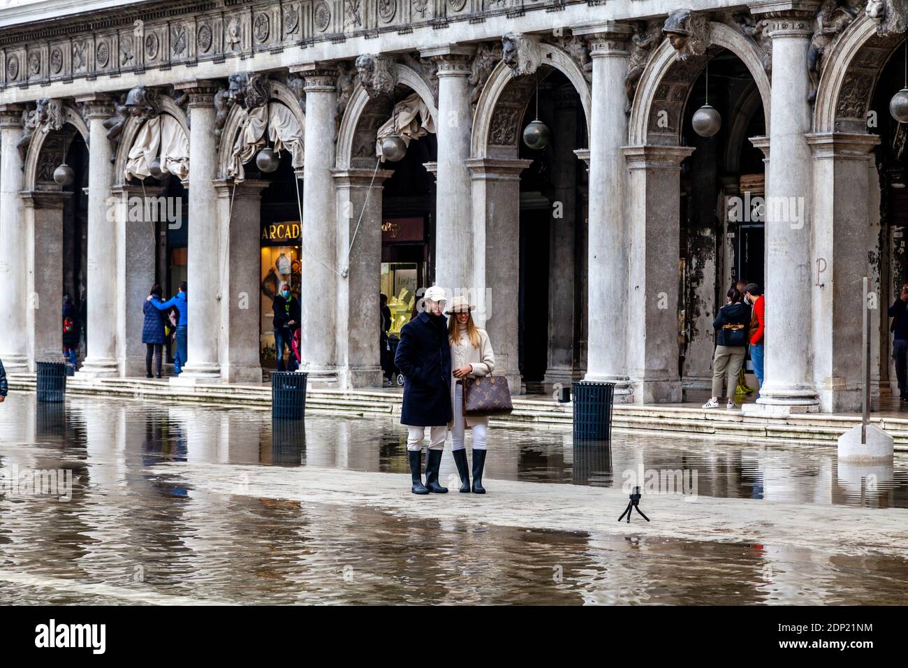 Una giovane coppia prende UN selfie durante l'acqua alta (alta marea) Piazza San Marco, Venezia, Italia. Foto Stock