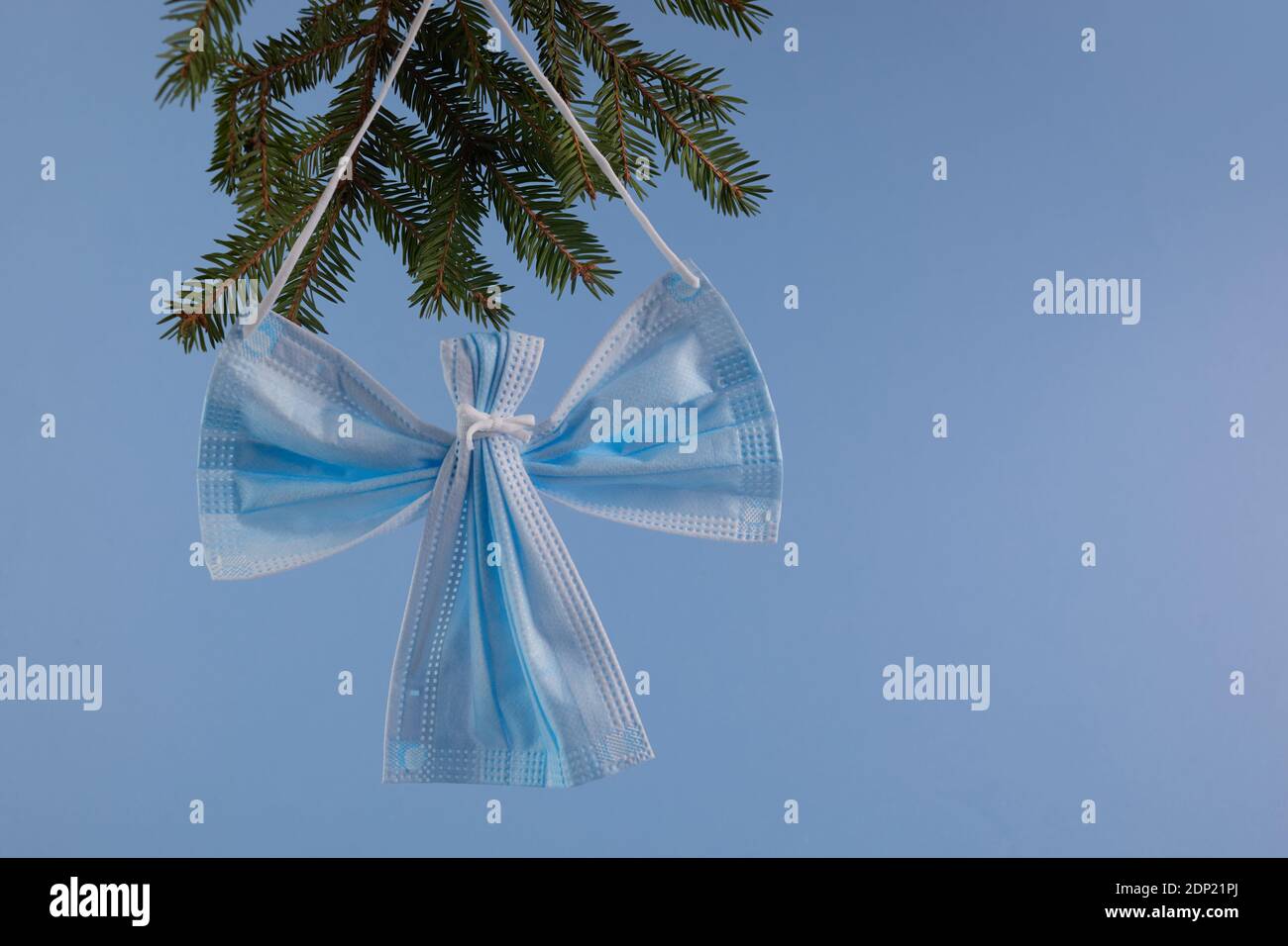 Angelo realizzato con maschera di protezione del viso su sfondo blu.  Concetto di Natale pn pandemic Foto stock - Alamy