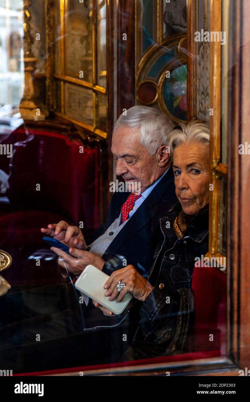Una coppia senior seduta all'interno del caffe Florian, Piazza San Marco, Venezia, Italia. Foto Stock