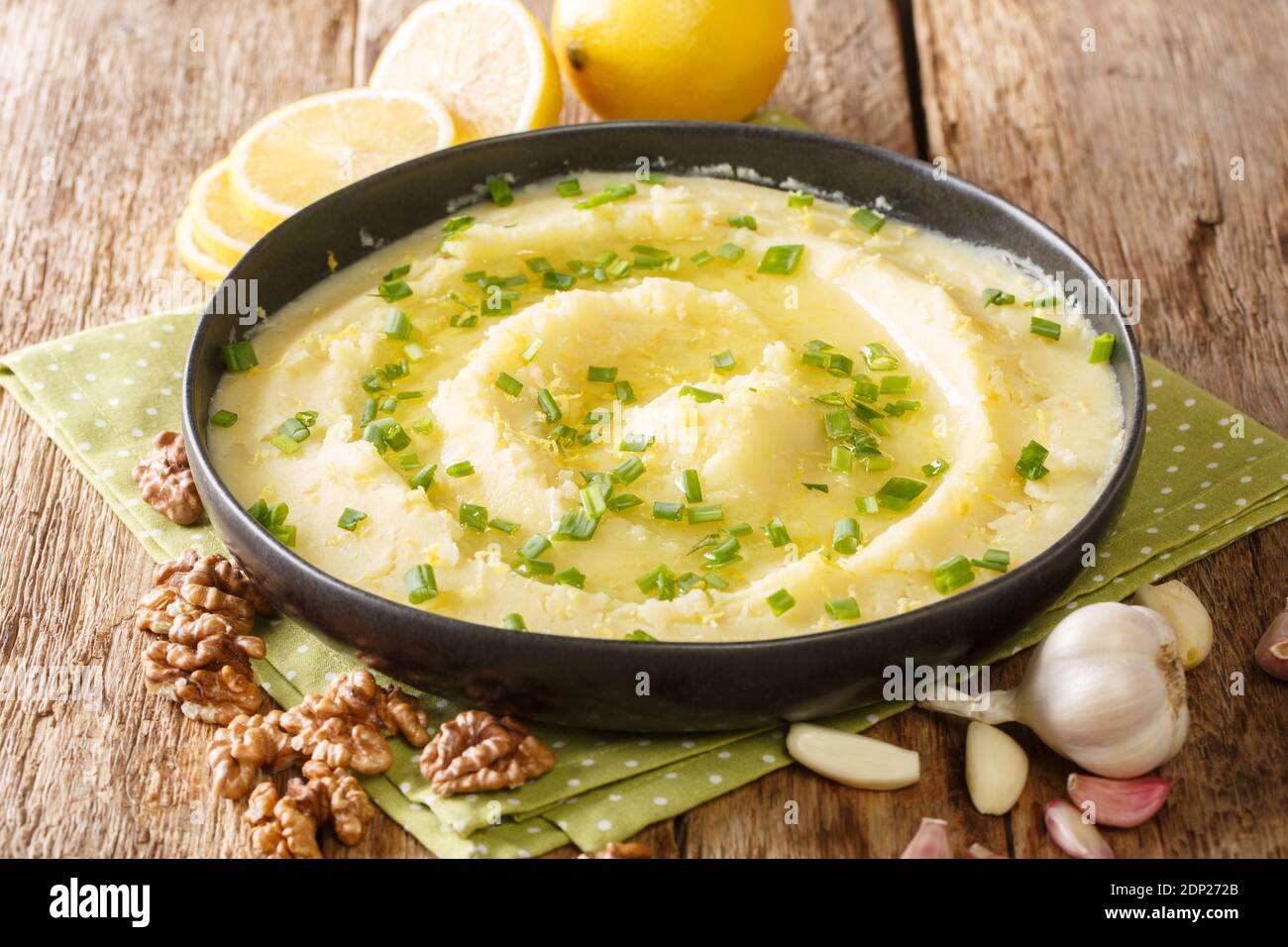 Antipasto tradizionale fatto in casa Skordalia fatto di purè di patate con aglio, limone, noci e olio d'oliva primo piano su un piatto sul tavolo. Orizzontale Foto Stock