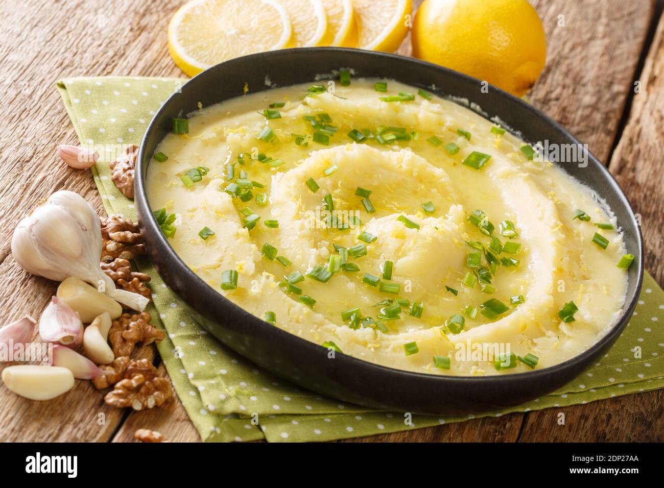 Delizioso Skordalia greco a base di purè di patate con aglio, limone, noci e olio d'oliva primo piano in un piatto sul tavolo. Orizzontale Foto Stock