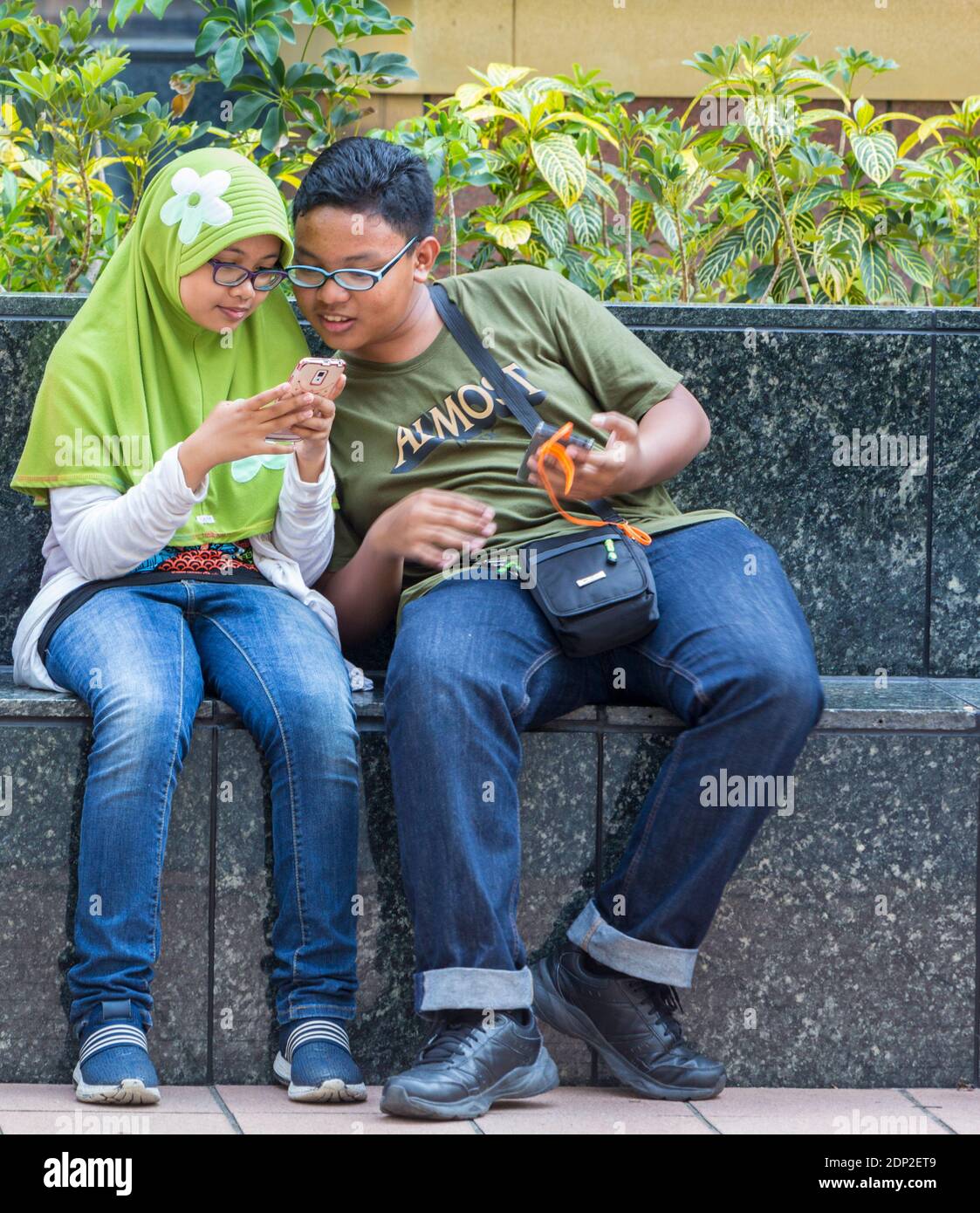 Di Singapore, Orchard Road Street scene. I giovani abitanti di Singapore con i loro telefoni cellulari. Foto Stock