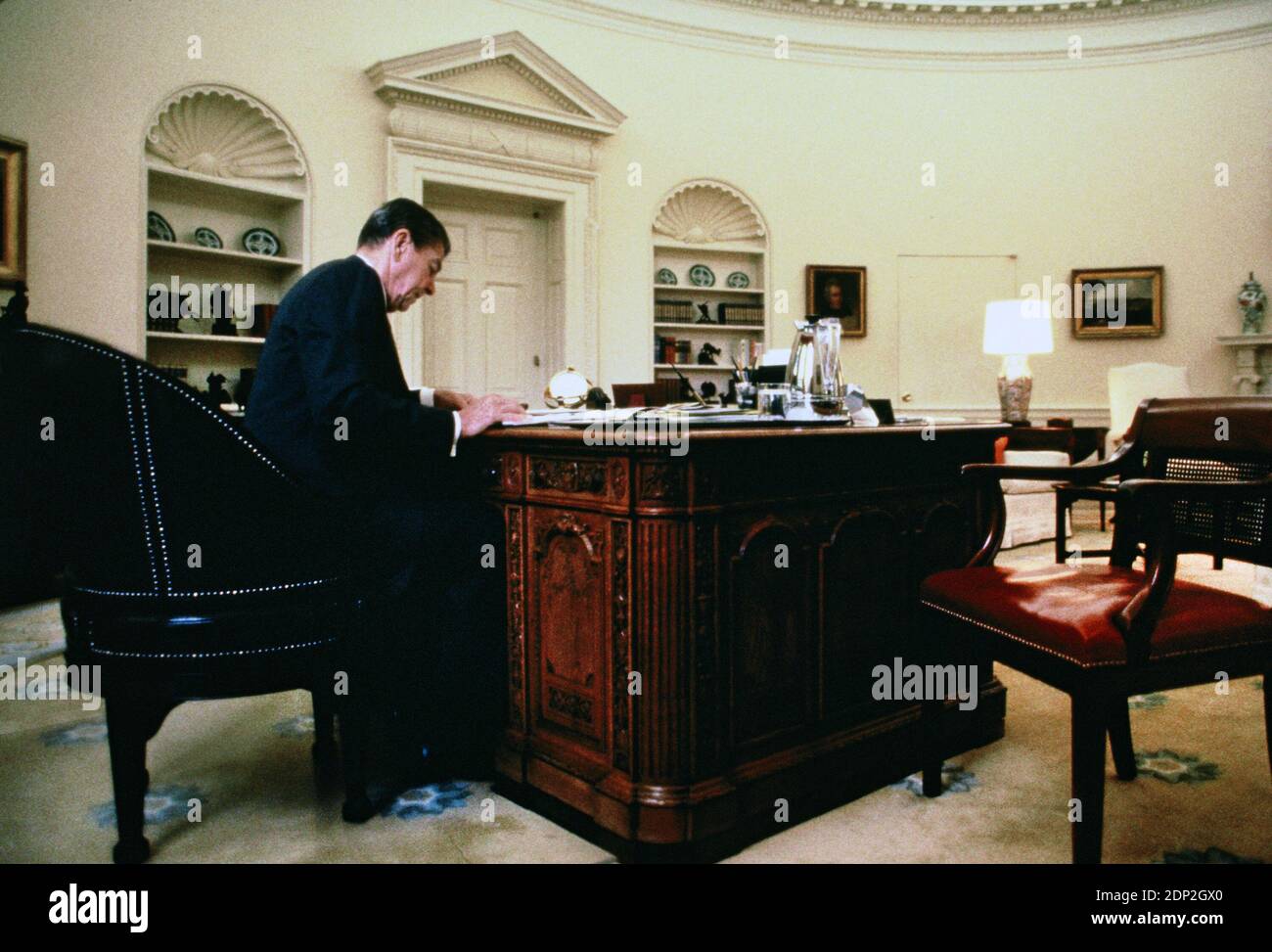 Il presidente Ronald Reagan lavora presso il Resolute Desk Ion The Oval Office nel 1985. Questa è stata una sessione esclusiva per una storia per una rivista, non ricordo quale fotografia di pubblicazione di Dennis Brack bb 75 Foto Stock