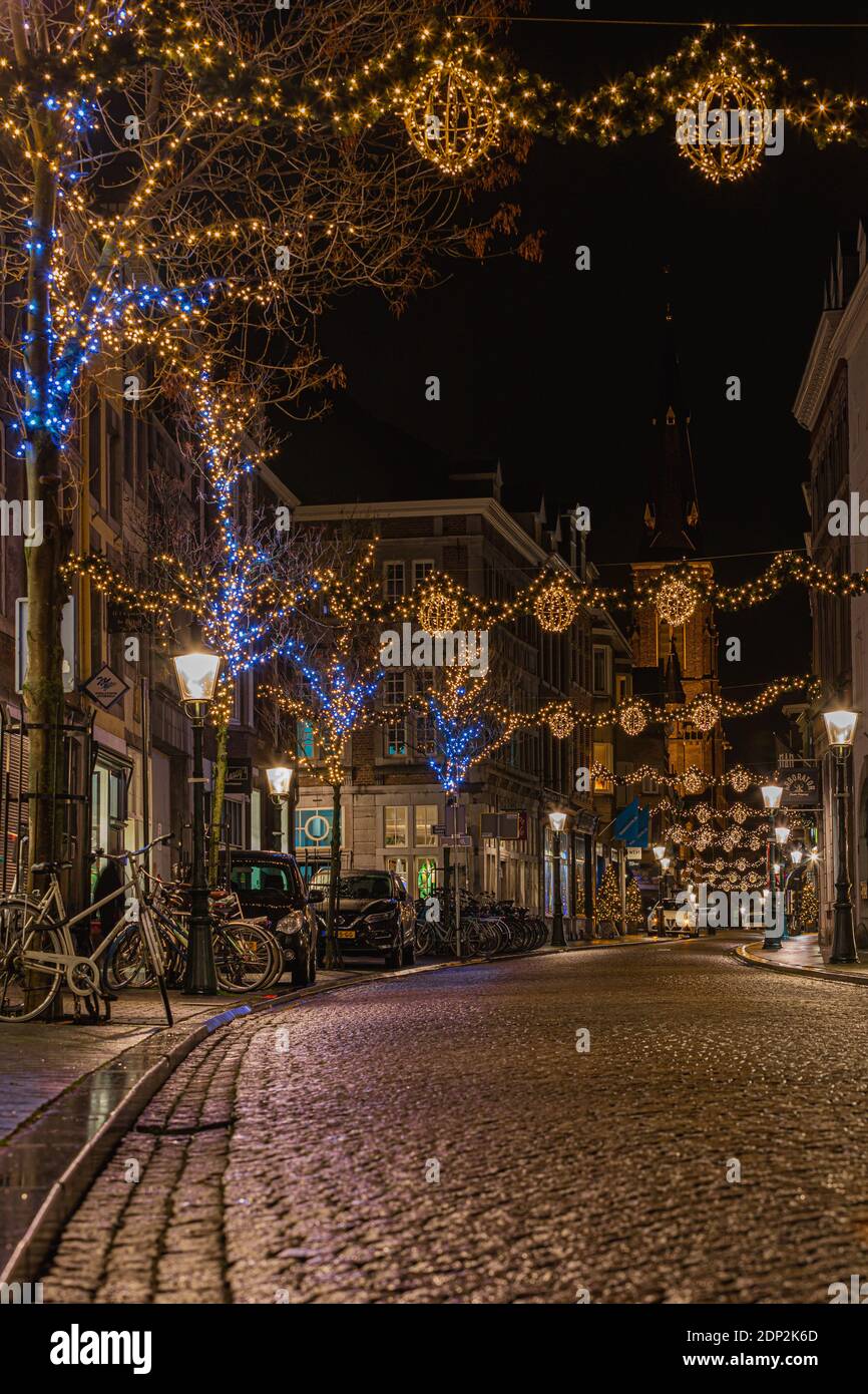 Bella illuminata e decorata Rechtstraat a Wyck, Maastricht pronto a ricevere i clienti nei negozi locali per acquistare i regali annuali di Natale. Foto Stock