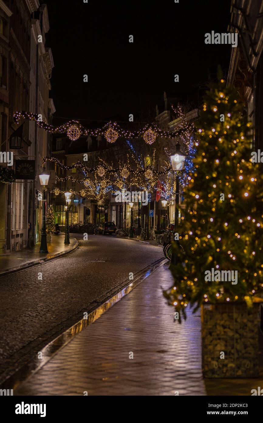 Bella illuminata e decorata Rechtstraat a Wyck, Maastricht pronto a ricevere i clienti nei negozi locali per acquistare i regali annuali di Natale. Foto Stock