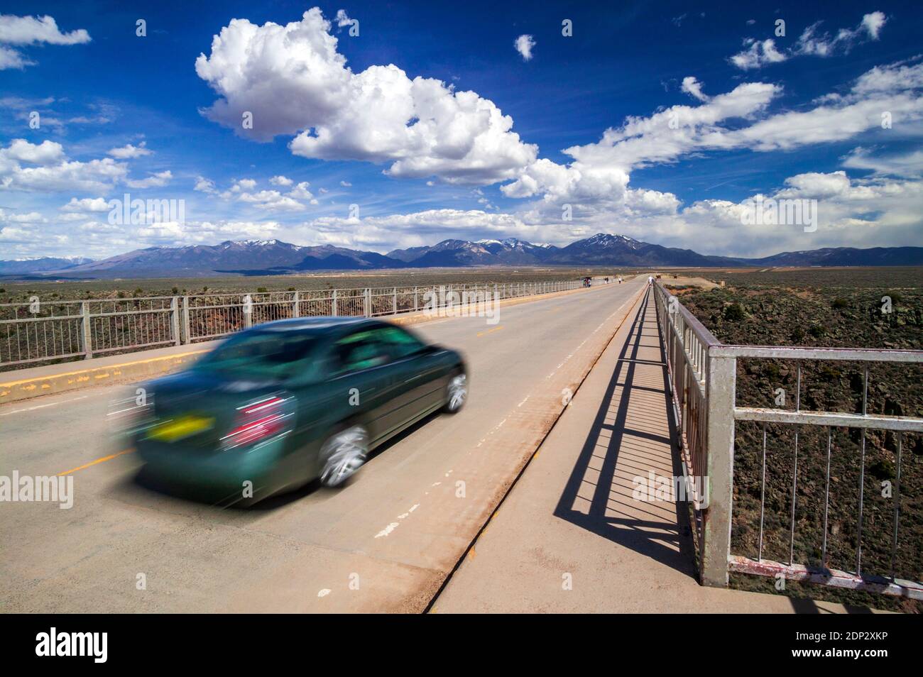 Offuscare l'immagine del movimento pan del veicolo che viaggia su un ponte di acciaio sul Rio Grande River vicino a Taos, New Mexico, USA Foto Stock