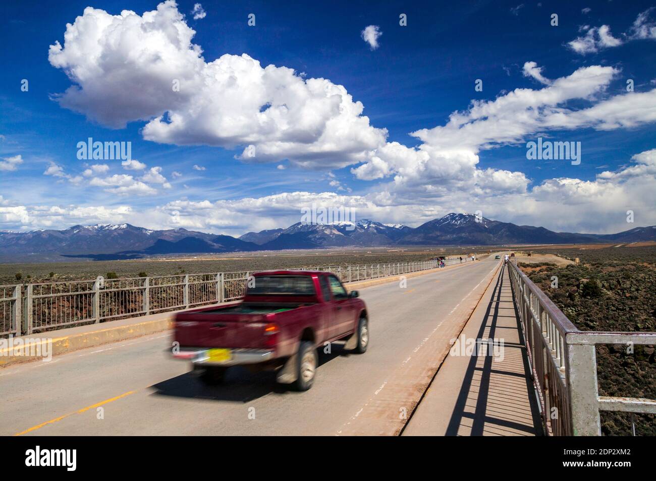 Offuscare l'immagine del movimento pan del veicolo che viaggia su un ponte di acciaio sul Rio Grande River vicino a Taos, New Mexico, USA Foto Stock