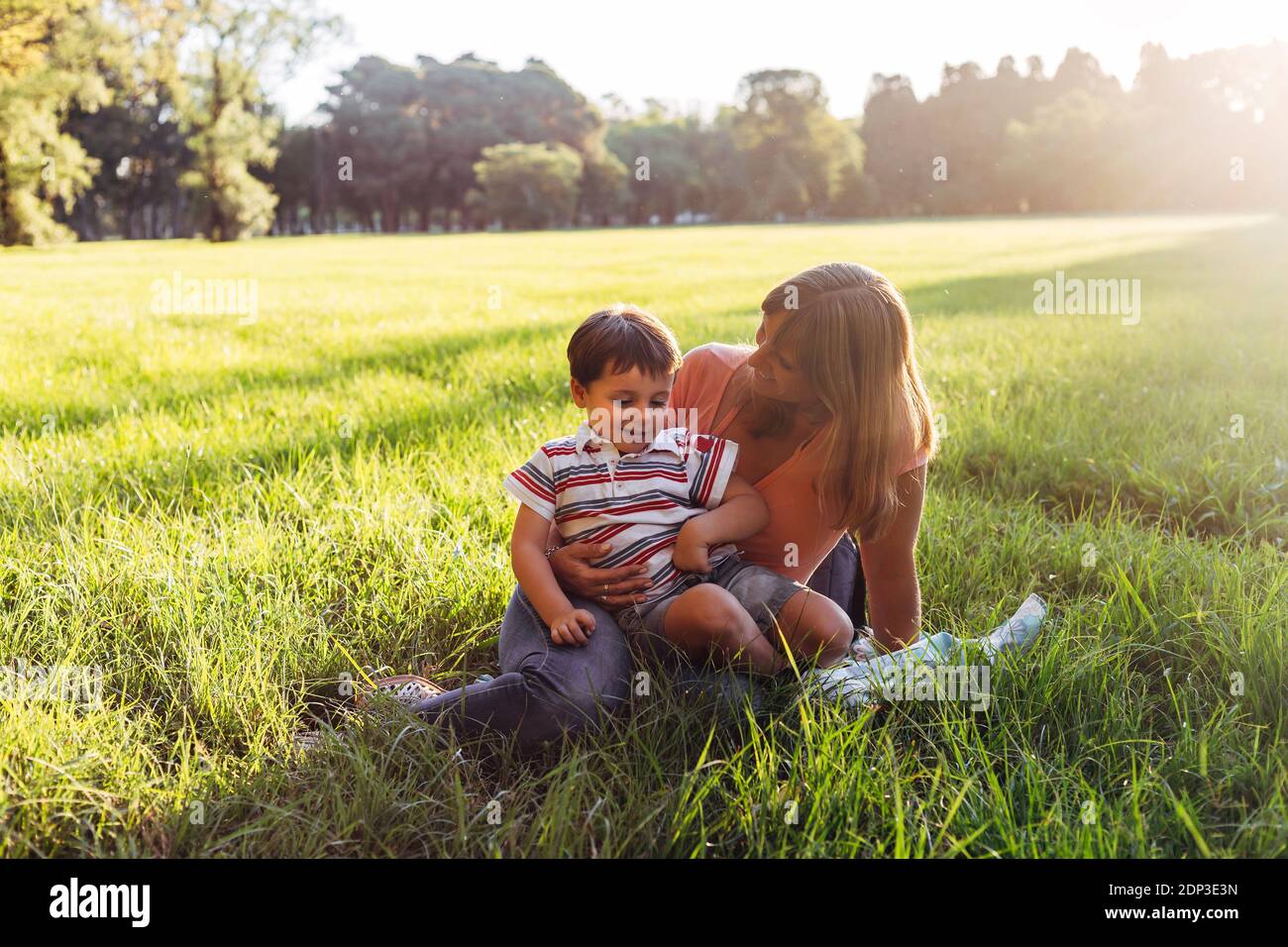 Madre e figlio nel parco al tramonto. Foto Stock