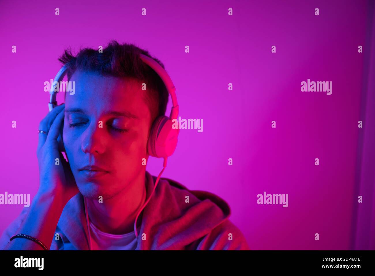 L'uomo ascolta la musica con le cuffie su uno sfondo colorato. Poster musicale Foto Stock