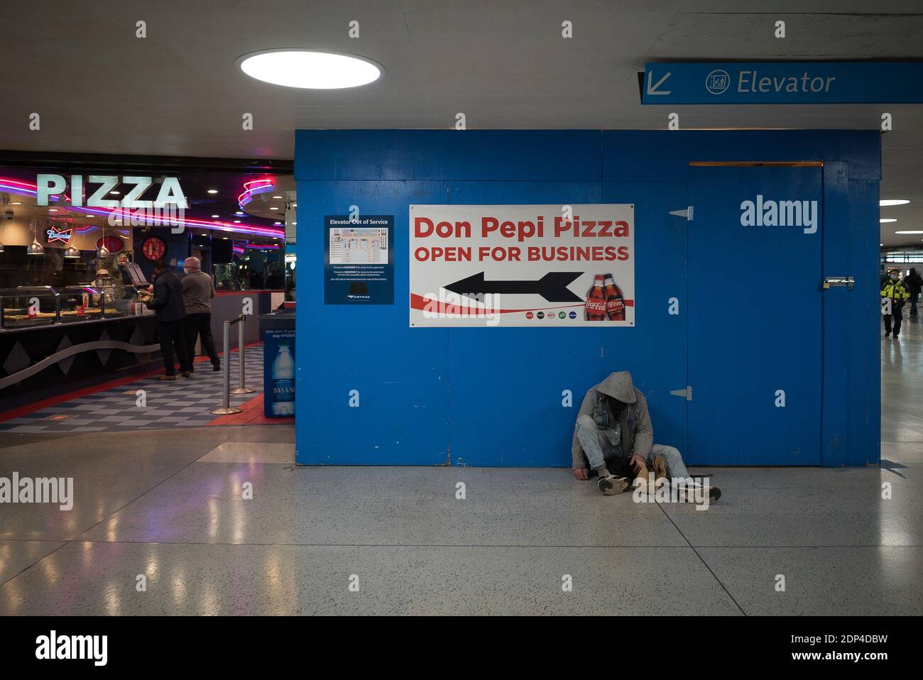 Manhattan, New York. 15 dicembre 2020. Un uomo senza casa dorme vicino all'ingresso di un ristorante pizza a Pennsylvania Station in Midtown. Foto Stock