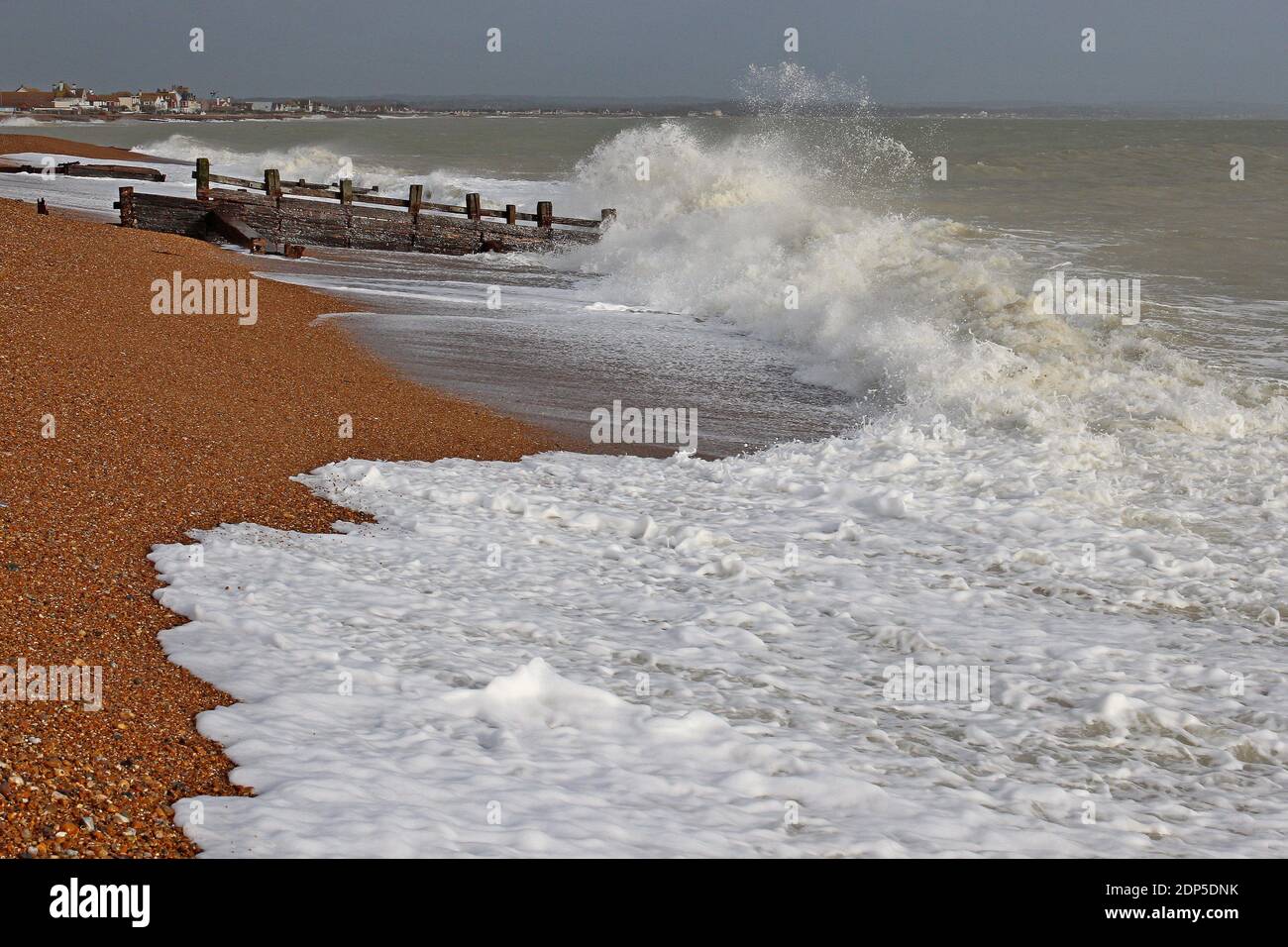 Vecchi groynes intemperie che proteggono la spiaggia di Pevensey Bay sulla costa meridionale dell'Inghilterra. Senza groynes la spiaggia soffrirebbe di erosione. Foto Stock
