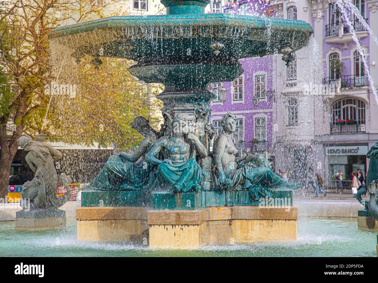 Lisbona, la fontana di Piazza Rossio e i colorati edifici storici del centro storico della città. Foto Stock
