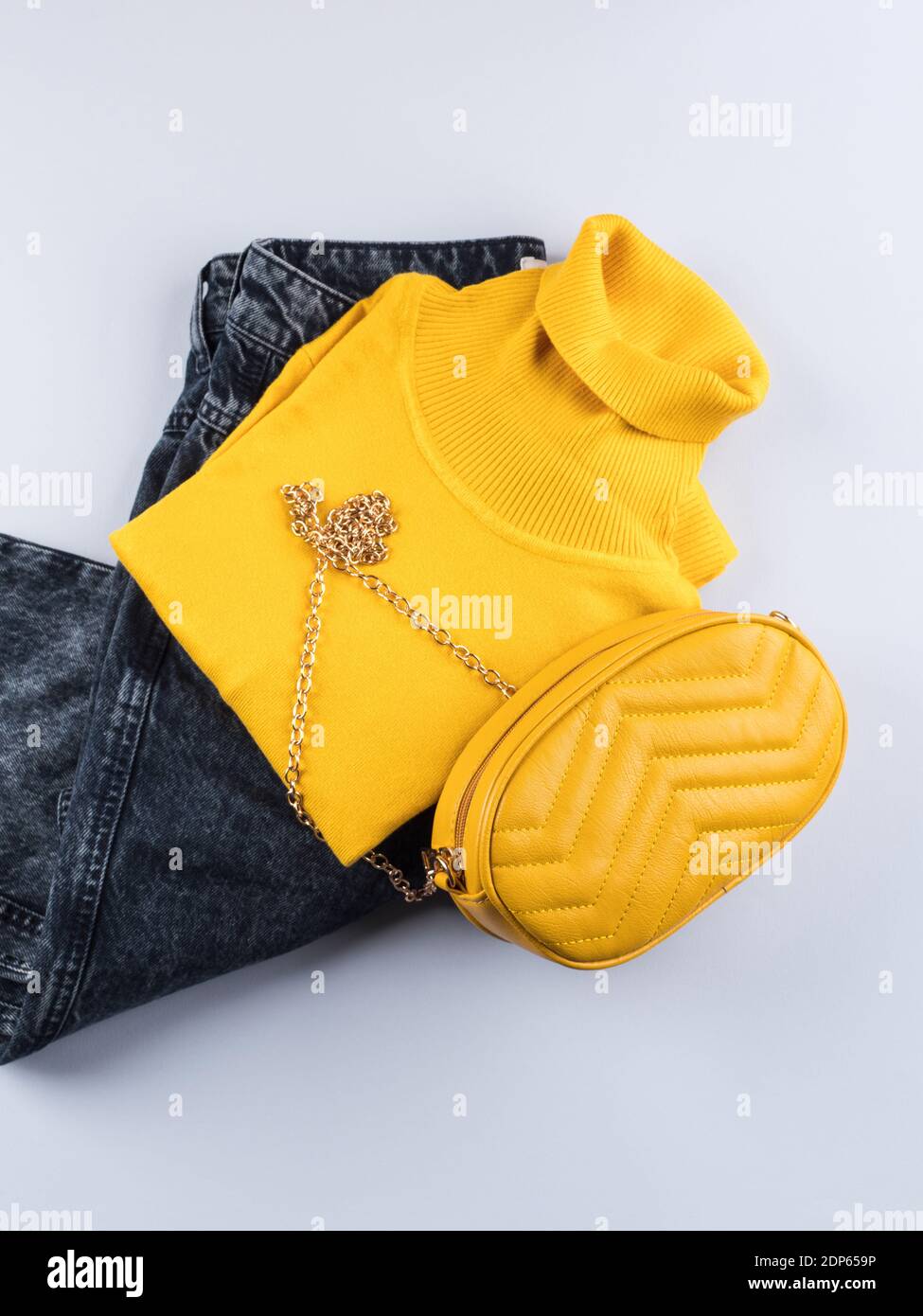 Outfit di moda con collo di tartaruga e borsa gialla Foto Stock