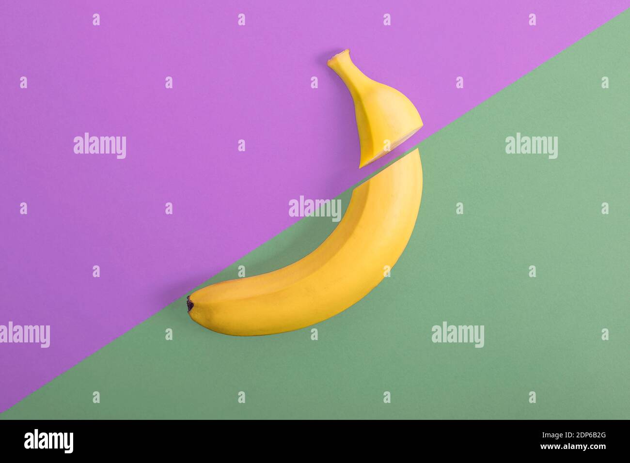 banana su sfondo verde viola, minimalismo piatto Foto Stock