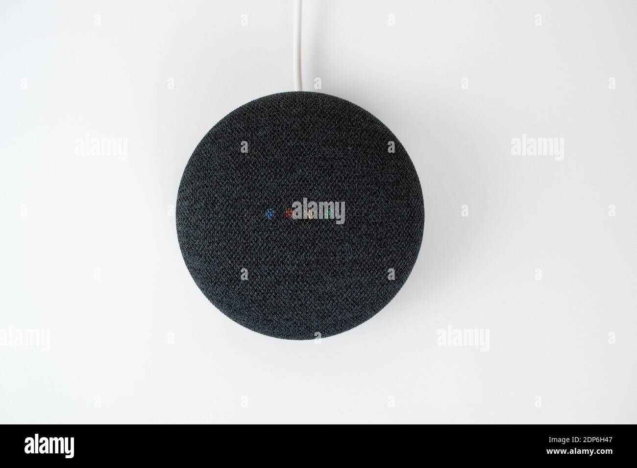 Londra, Regno Unito - 19 dicembre 2020: Antracite Google Nest Home Mini altoparlante intelligente con integrato Google Assistant su sfondo bianco. Foto Stock