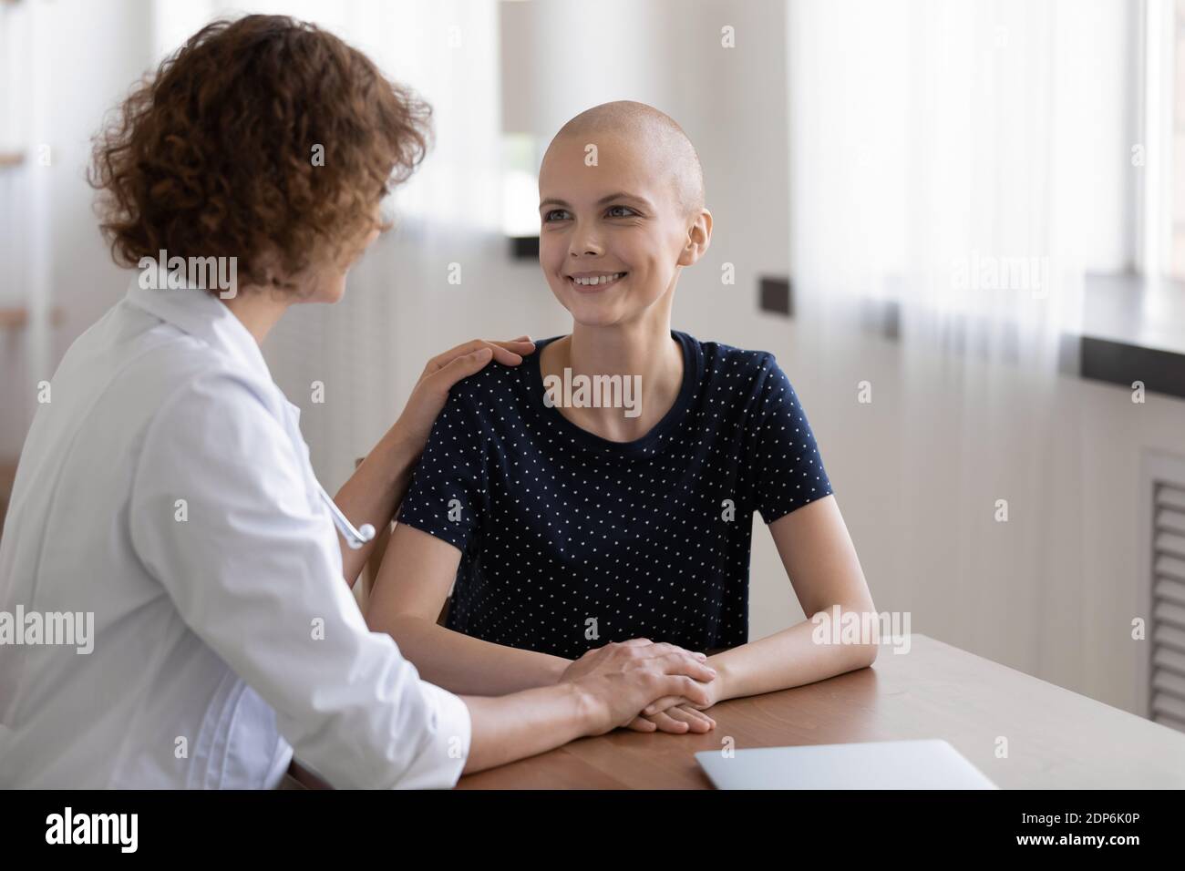 Giovane donna malata speranzosa siediti alla scrivania Ascolta il medico Foto Stock
