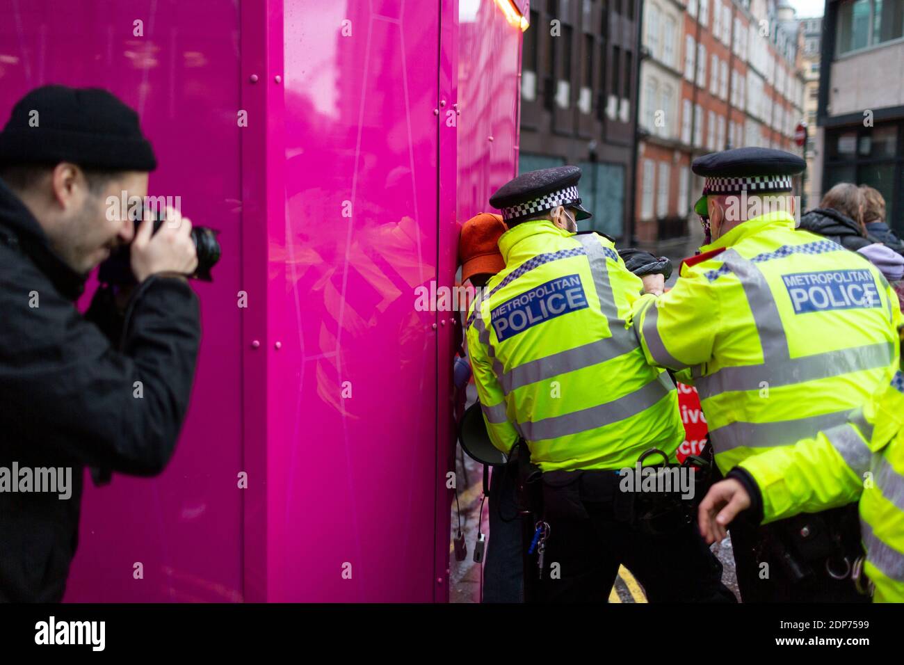 Un fotografo cattura un arresto durante la protesta contro il vaccino COVID-19, Westminster, Londra, 14 dicembre 2020 Foto Stock