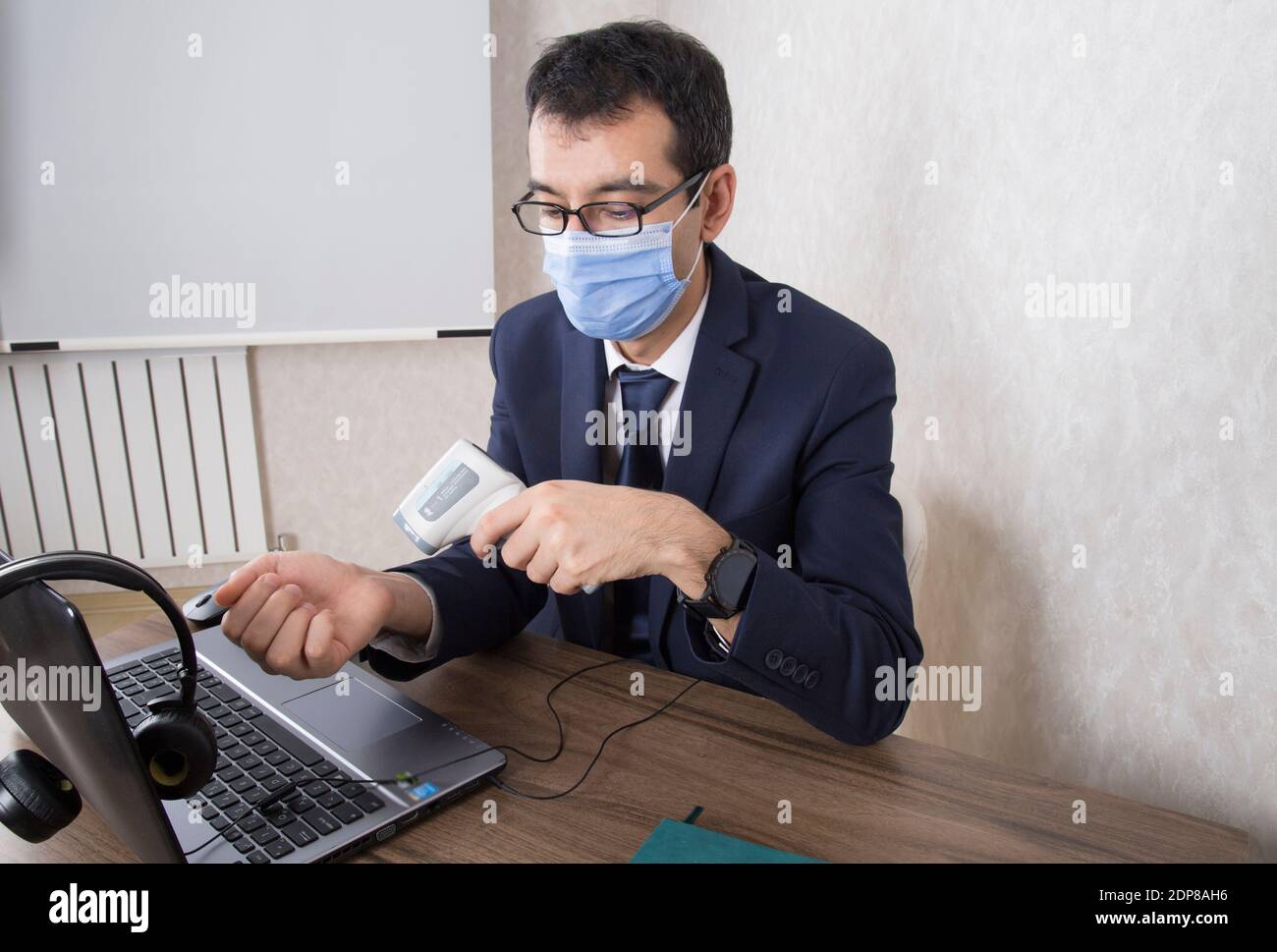 nuovo ufficiale di ordine regolare che misura la febbre per proteggere contro il coronavirus Foto Stock