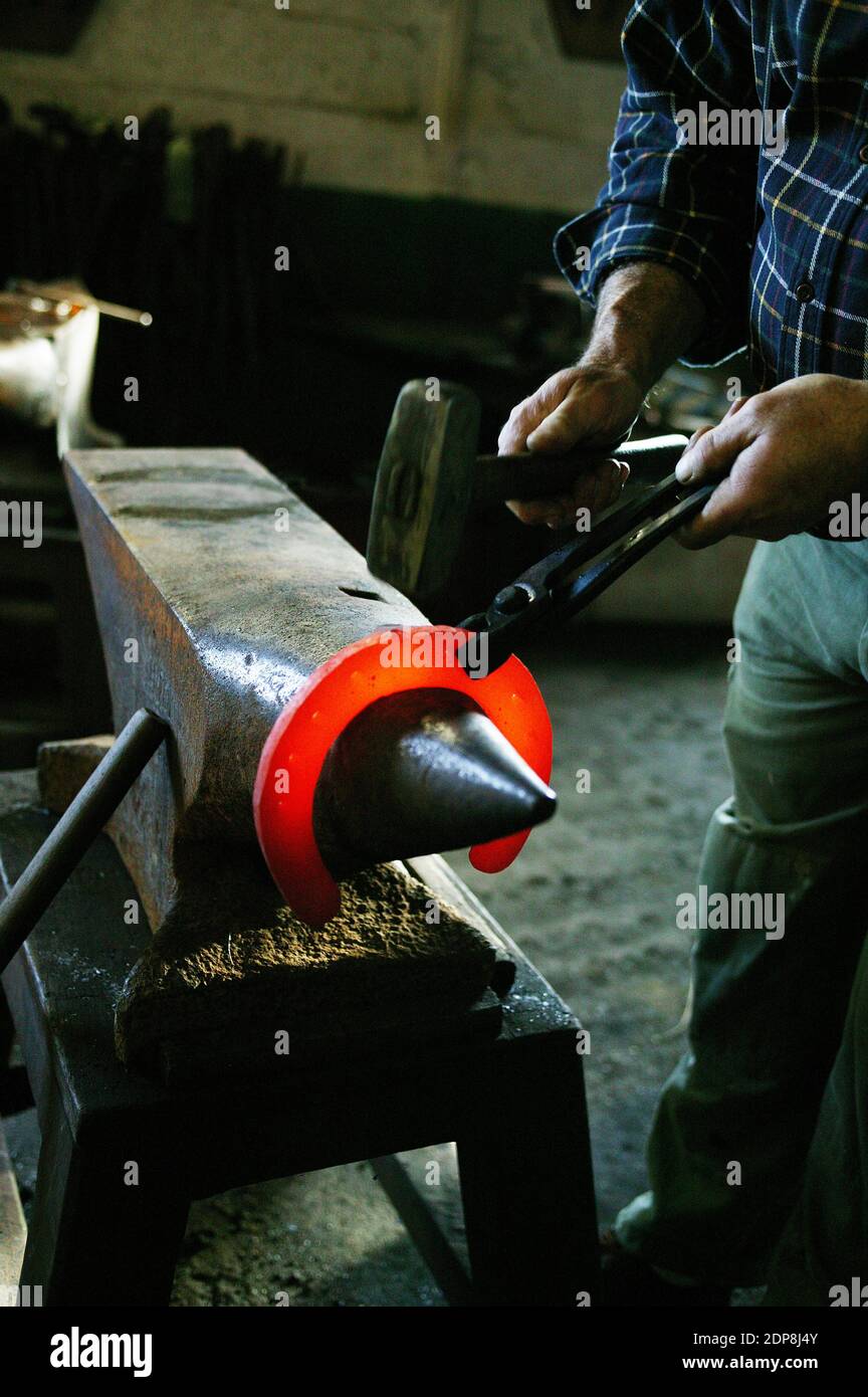 Fucina Fabbro, a ferro di cavallo in produzione da una barra di timone Foto Stock