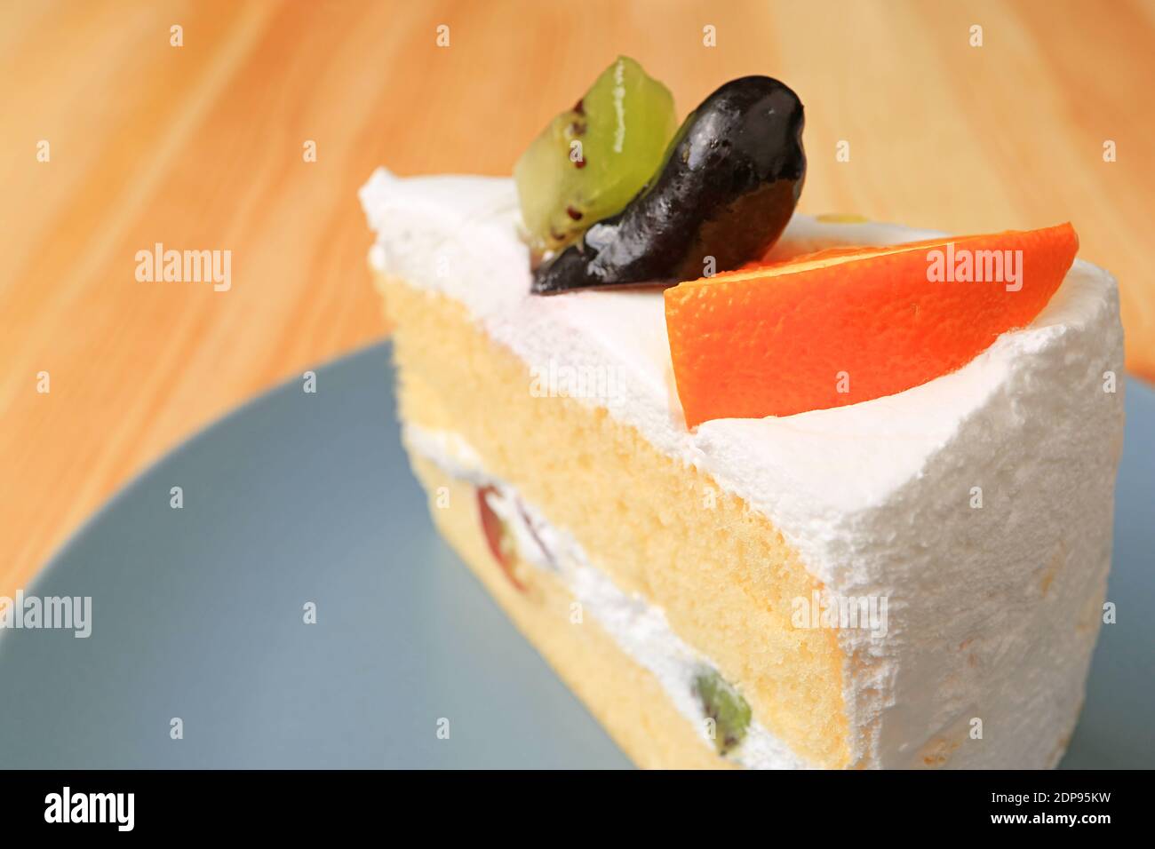Primo piano di torta di Chiffon alla vaniglia con frutta fresca Tavola di legno Foto Stock