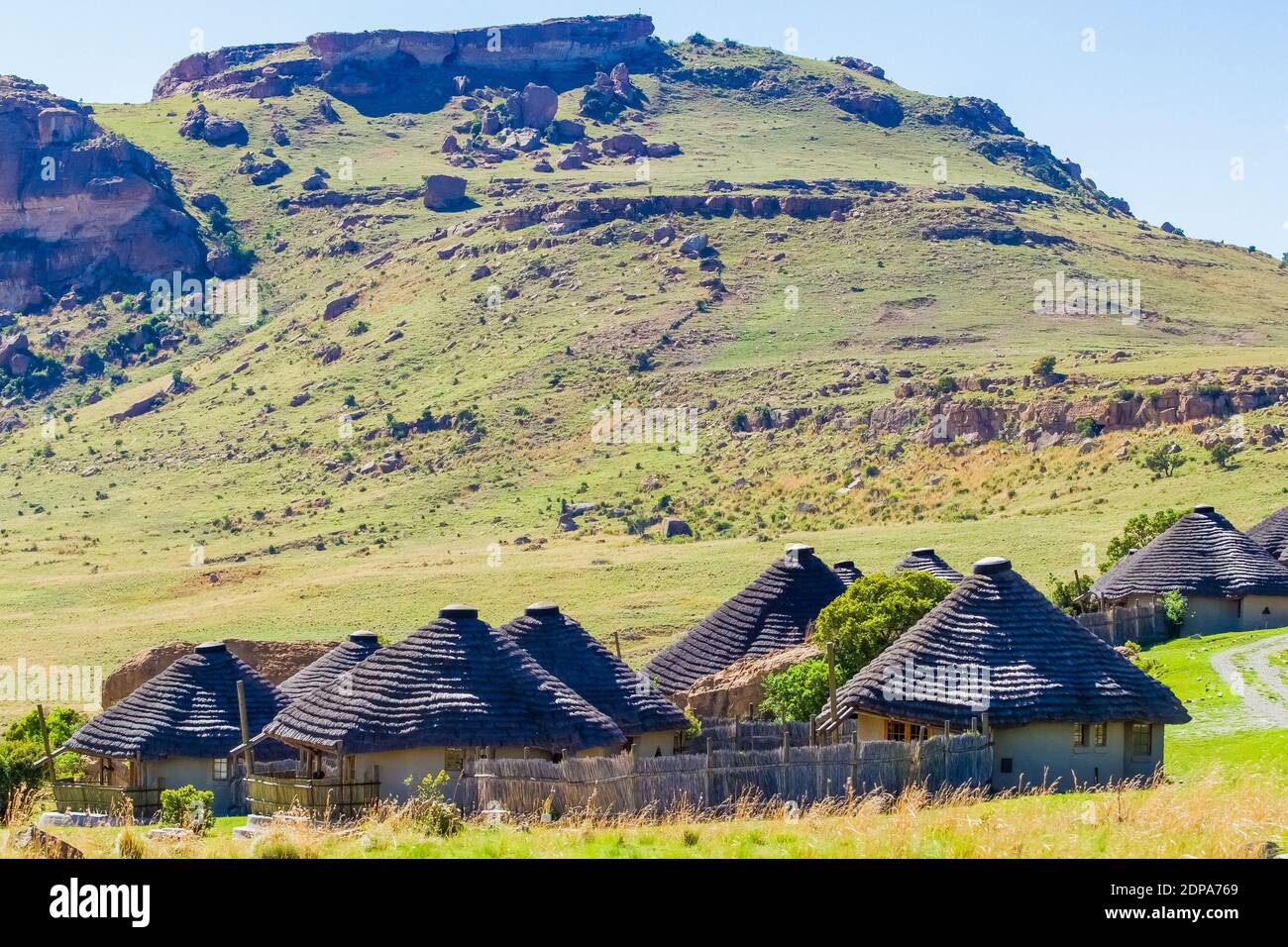 Un piccolo villaggio di rondavels africani sullo sfondo di a. collina rocciosa Foto Stock