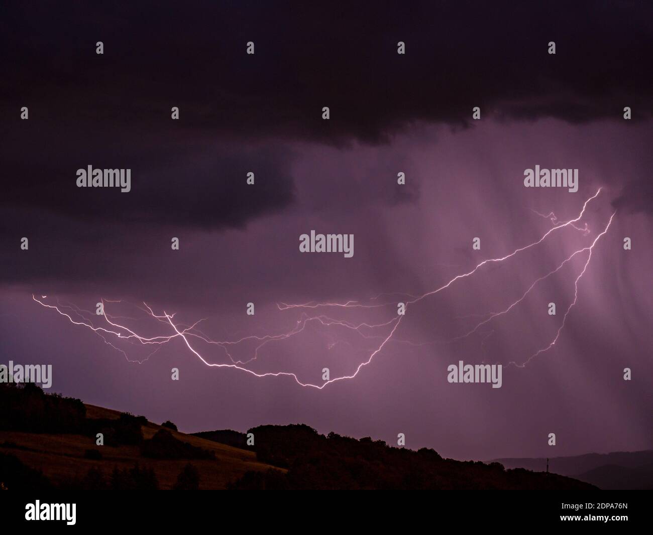 Tempesta con fulmine su paesaggio collinare - esposizione lunga a. notte Foto Stock