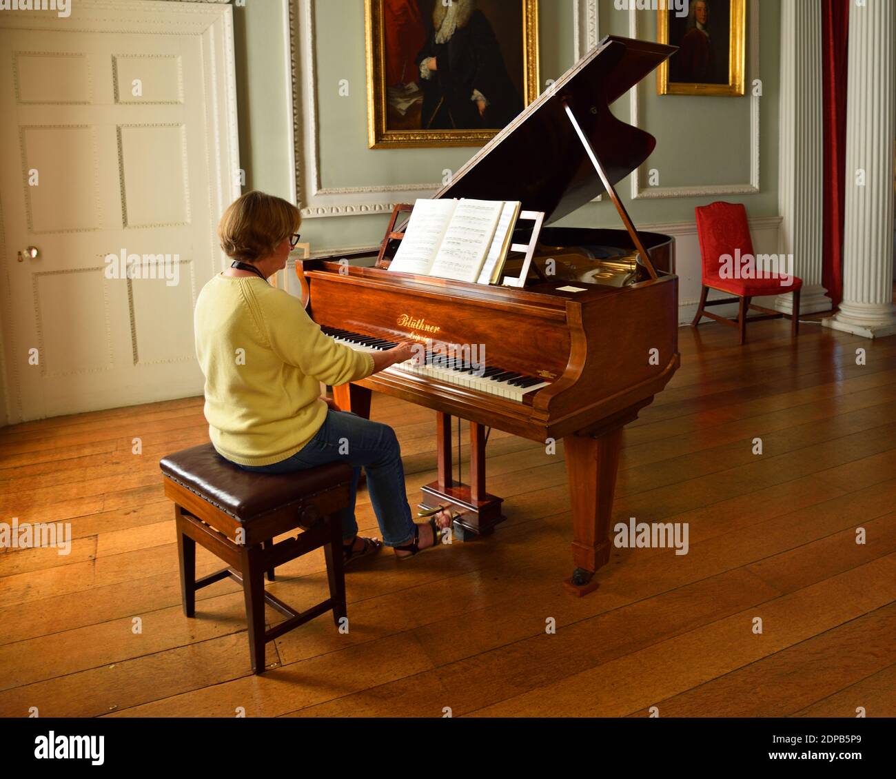 Donna che gioca a Bluthner Grand piano nella bellissima Old Room. Foto Stock