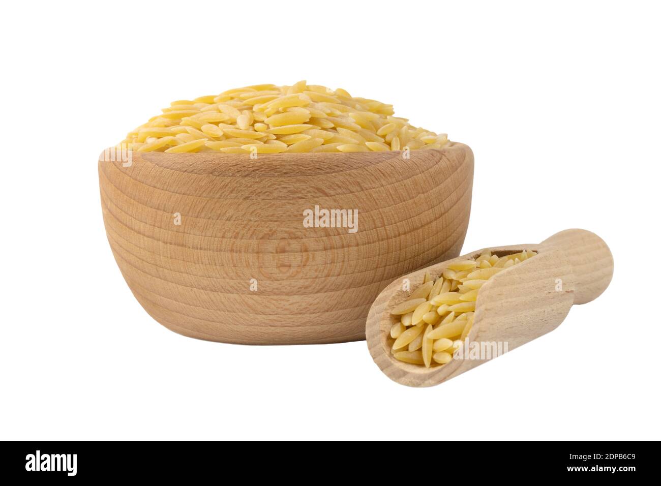 In Grecia chiamato kritharaki. In Italia si chiama Orzo. Pasta a forma di riso in recipiente di legno e paletta isolata su sfondo bianco. Tipo di pasta. Cibo ingerito Foto Stock