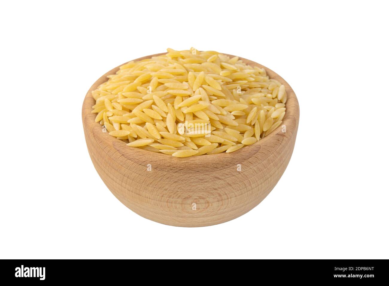 In Grecia chiamato kritharaki. In Italia si chiama Orzo. Pasta a forma di riso in ciotola di legno isolata su sfondo bianco. Tipo di pasta. Ingrediente alimentare. Foto Stock